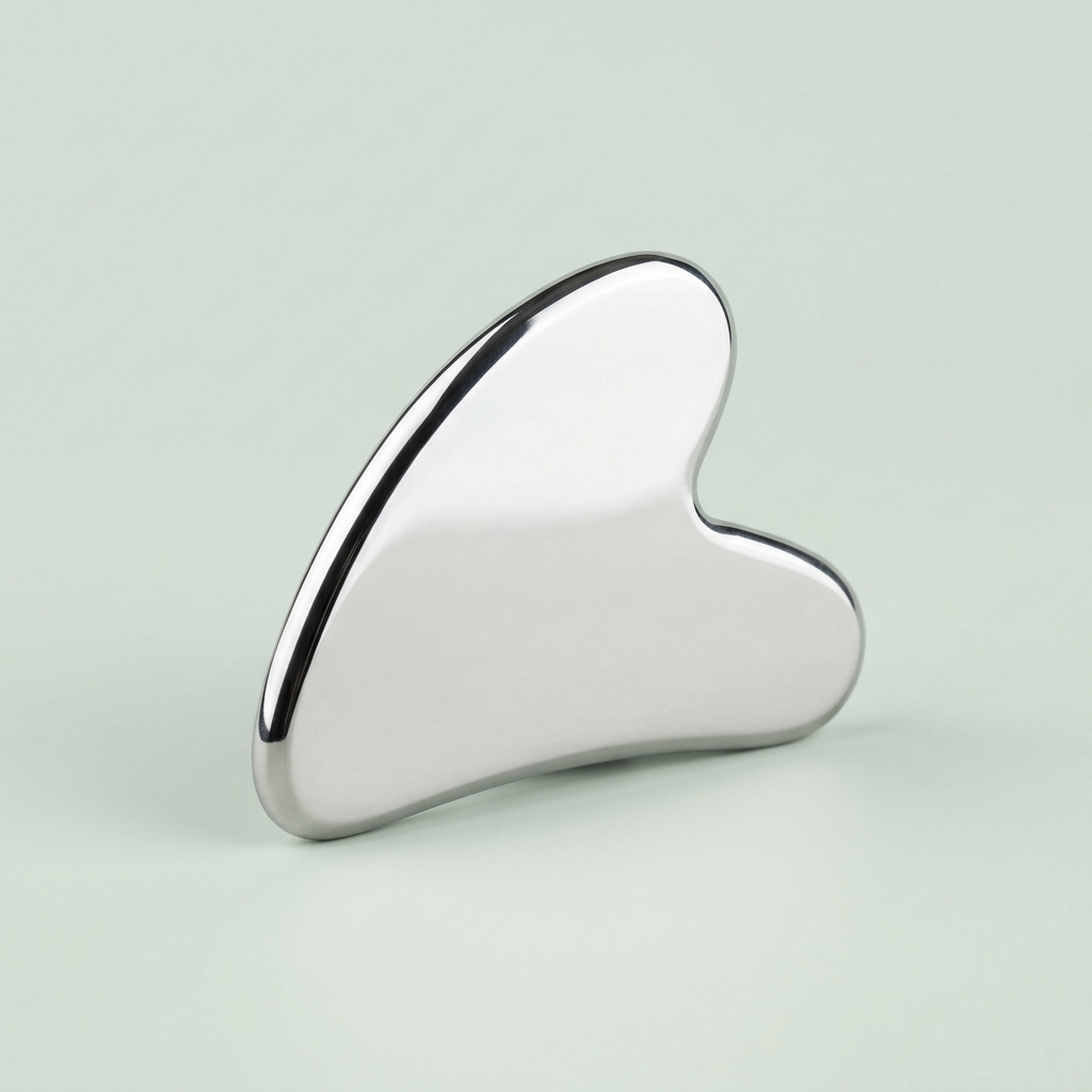 Silver Gua Sha tool on a light gray background